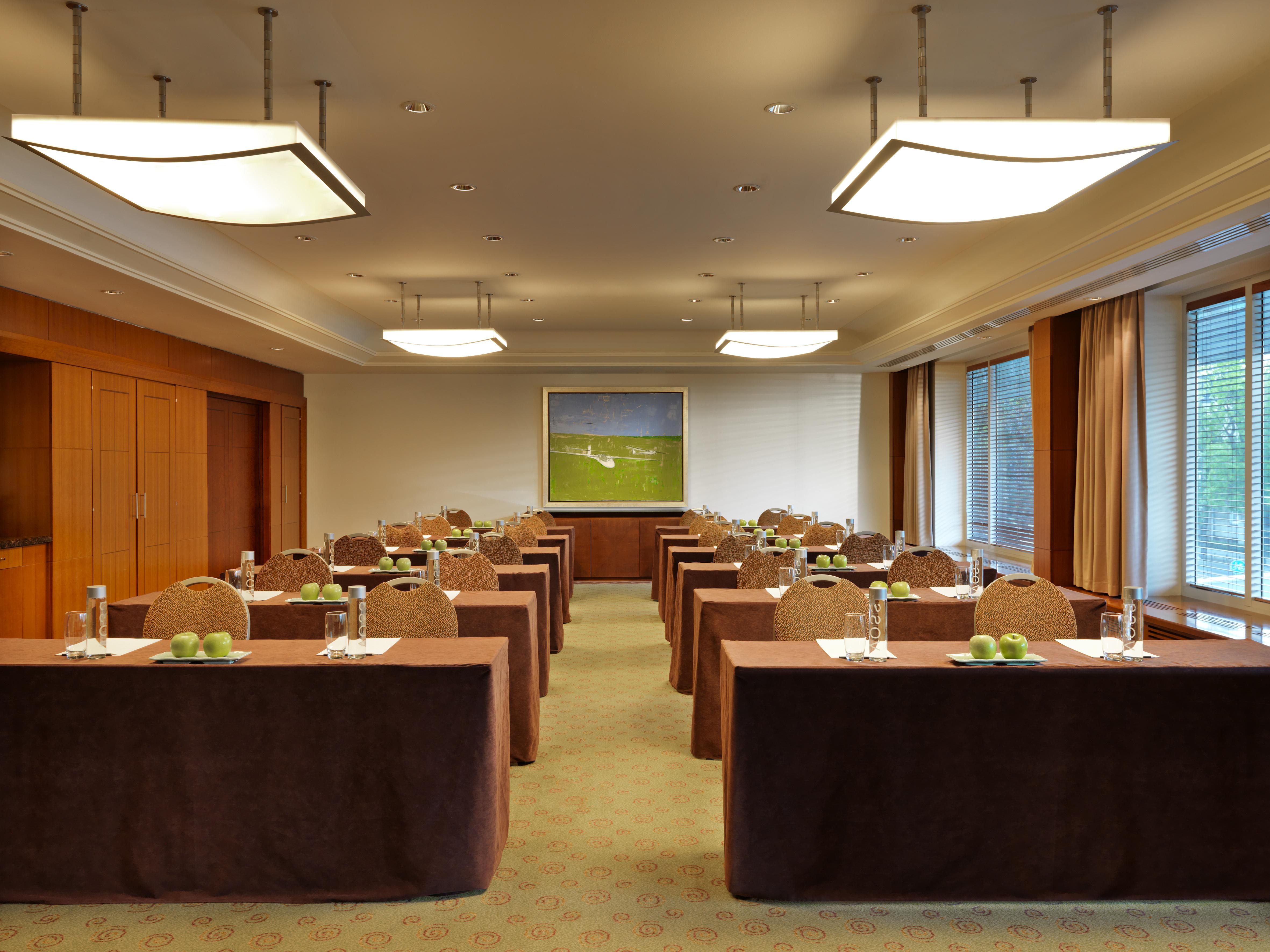 Regent Warsaw Hotel Exterior foto The photo depicts a conference or meeting room. The room is arranged with several rectangular tables set up in rows, each covered with brown tablecloths. On each table, there are glass water bottles and small green apples, suggesting preparation for 