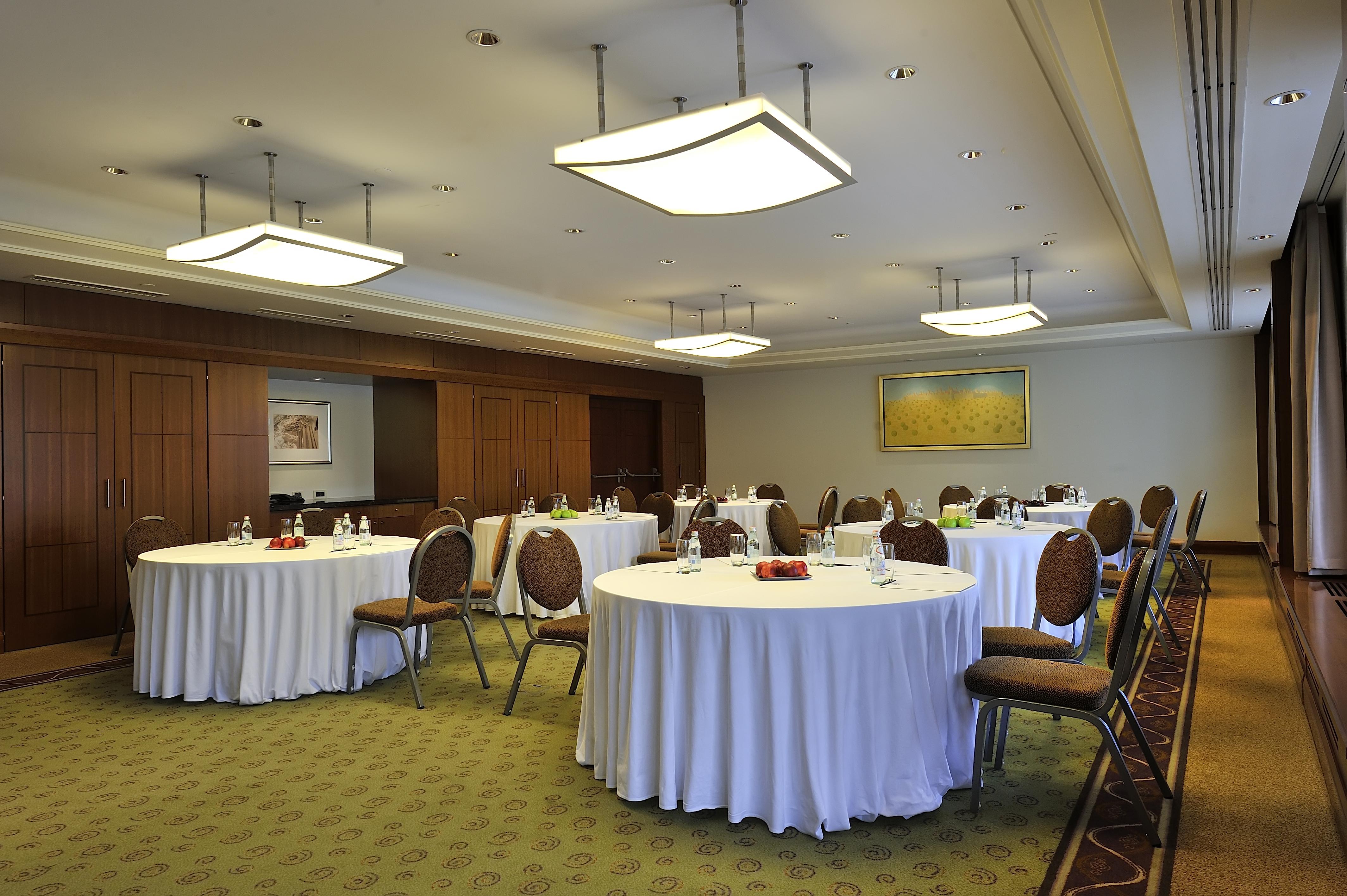 Regent Warsaw Hotel Exterior foto The photo depicts a conference or meeting room. It features several round tables covered with white tablecloths. Each table has chairs around it, and there are items such as water bottles and possibly snacks on the tables. The room has modern lightin