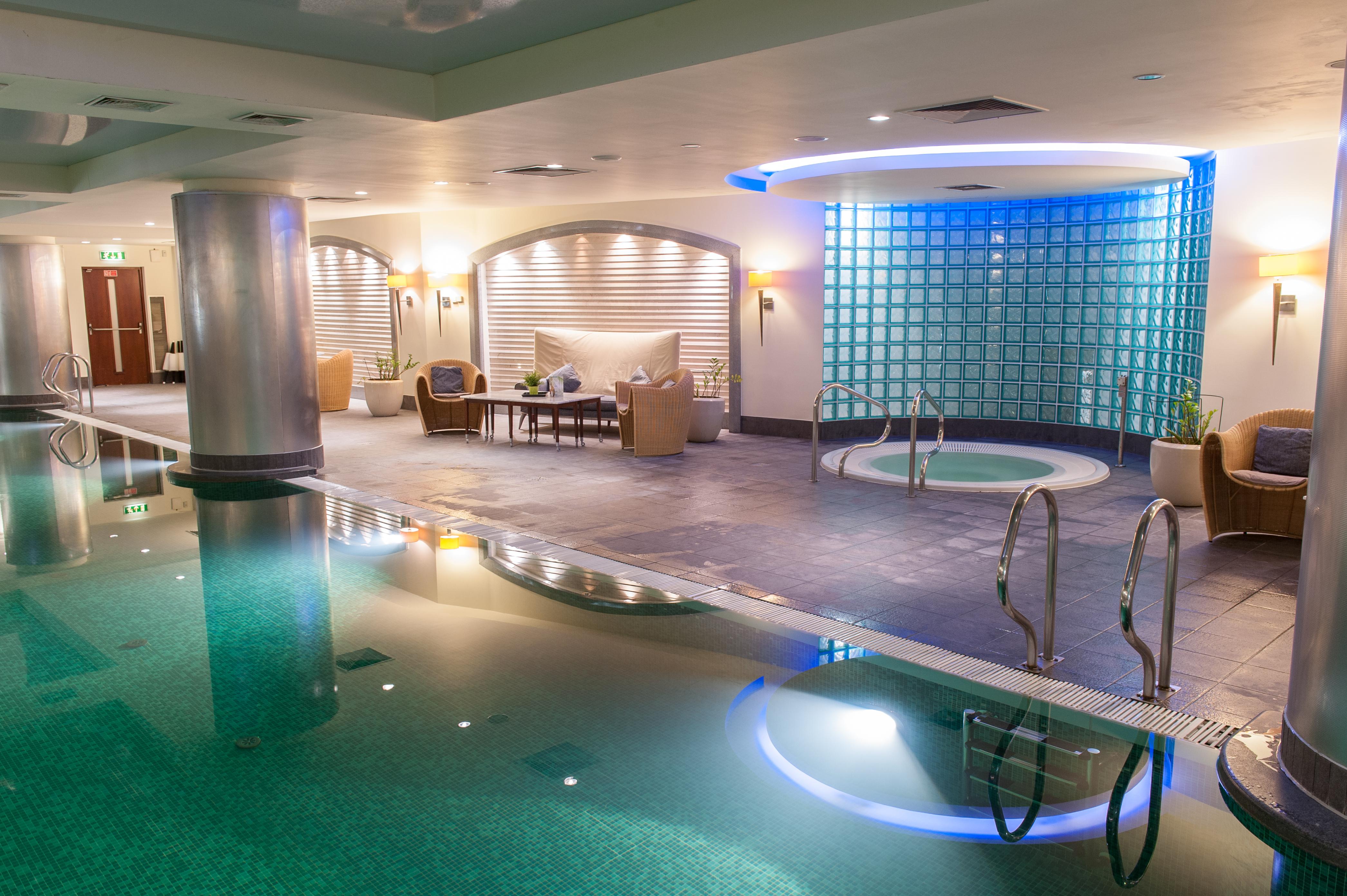 Regent Warsaw Hotel Exterior foto The photo shows a spa area featuring a calm and relaxing atmosphere. There is a swimming pool with clear water reflecting the soft lighting. To one side, there is a hot tub with steps leading into it. The walls are adorned with light-colored material