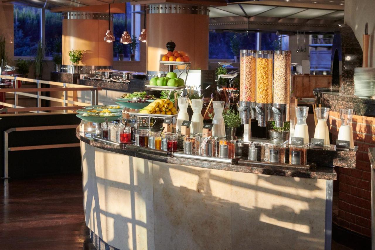 Regent Warsaw Hotel Exterior foto The photo shows a beautifully arranged buffet area in a restaurant or hotel. There is a curved counter featuring an array of fresh fruits, including apples and other colorful produce. Additionally, there are various containers displaying healthy opti